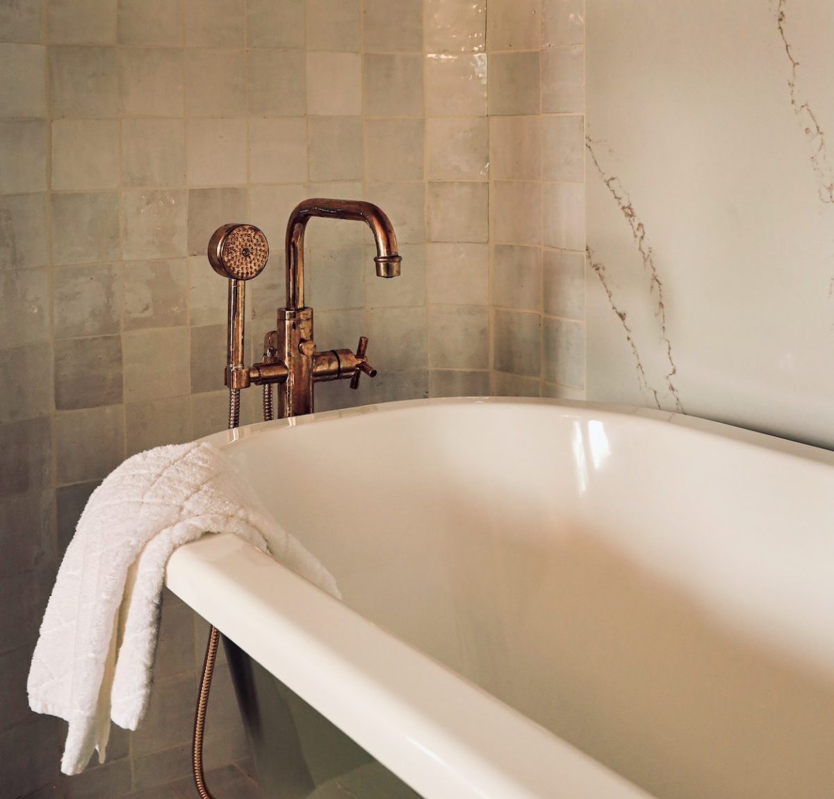 white ceramic bathtub with stainless steel shower head