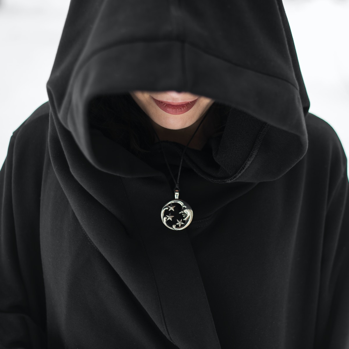 man in black hoodie standing on snow covered ground during daytime