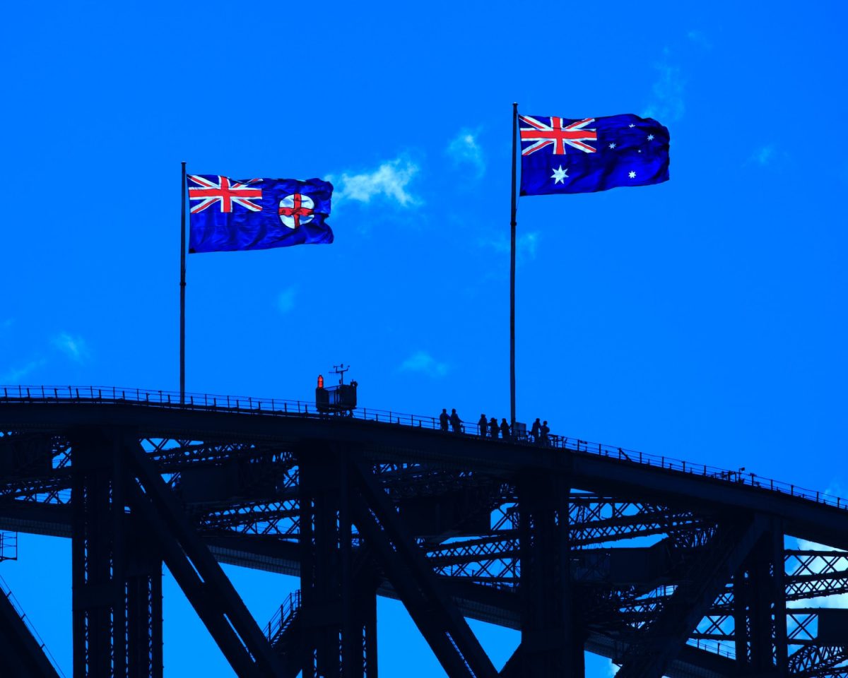 blue red and yellow flag on black metal bridge under blue sky during daytime